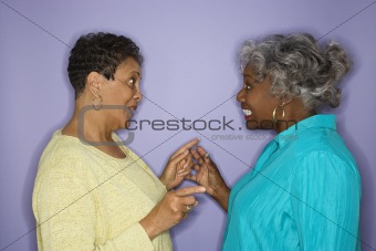 Women pointing at eachother.