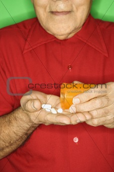 Man emptying pill bottle into hand.