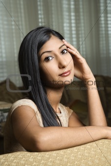 Young woman sitting on couch.
