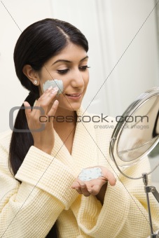 Young woman looking in mirror.