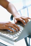 Young womans hands typing on laptop keyboard.