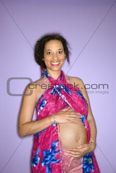 Pregnant woman with hands on stoomach.