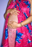 Pregnant woman with hands on stomach.