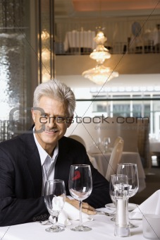 Adult male sitting at restaurant table.