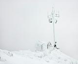 Cabin and antenna covered in snow.