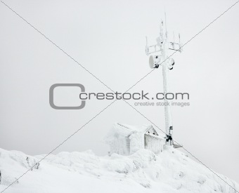 Cabin and antenna covered in snow.
