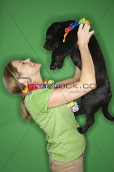 Woman holding black puppy.