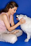 Woman petting white dog.
