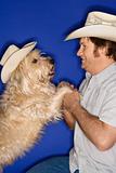 Dog and man wearing cowboy hats.