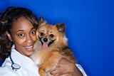 Woman veterinarian holding brown dog.