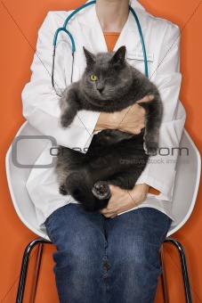 Veterinarian holding cat with one eye.
