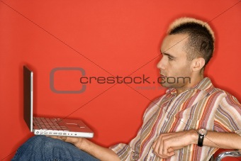 Caucasian man with mohawk with laptop.