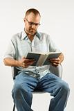 Caucasian man reading a book.