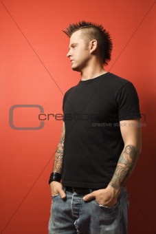Caucasian man with tattoos and mohawk.