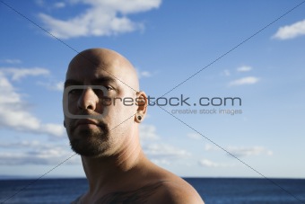 Adult bald male on beach.