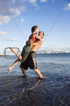 Young adult couple on beach.
