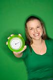 Caucasian young female adult holding out clock and smiling.