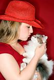 Caucasian female holding and kissing cat.