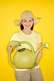 Young Caucasian woman holding watering can.