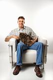 Caucasian man sitting holding Persian cat.