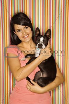 Caucasian woman holding Boston Terrier dog.