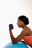 Profile woman lifting dumbbell.