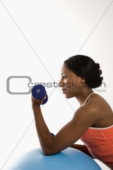 Profile woman lifting dumbbell.