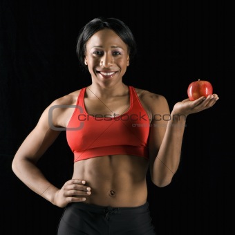 Athletic woman holding apple.