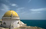 Yellow Dome of famous cathedral in Cadiz with Atlantic Ocean and blue sky