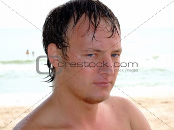 Portrait of a wet young man day at the beach