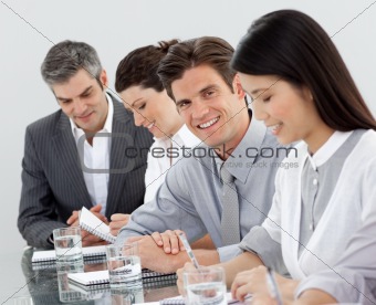 Multi-ethnic business people taking notes at a presentation 