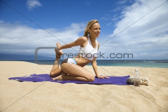 Attractive Young Woman Doing Yoga on Beach