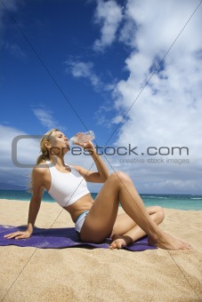 Attractive Young Woman Drinking on Beach
