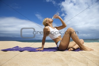 Attractive Young Woman Drinking on Beach