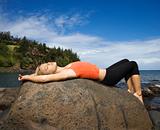 Attractive Young Woman Lying on Rock at Beach