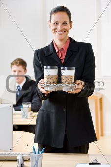 Businesswoman carrying tray of coffee