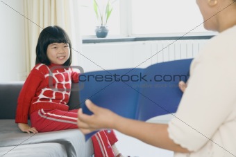 Woman Showing Book to Smiling Girl