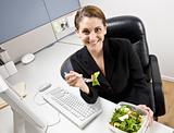 Businesswoman eating salad at desk