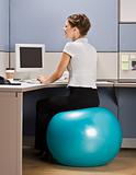 Businesswoman sitting on exercise ball at desk