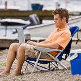 Man using laptop on beach