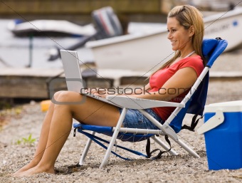 Woman using laptop on beach