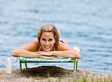 Woman laying on lounge chair at beach