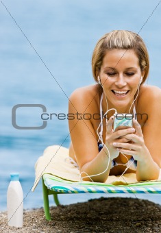 Woman listening to mp3 player at beach