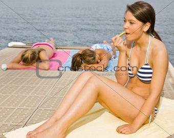 Woman on pier applying lip balm