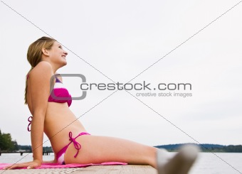 Woman sitting on pier at lake