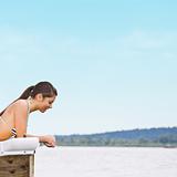 Woman laying on pier at lake