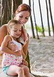 Mother and daughter listening to seashell