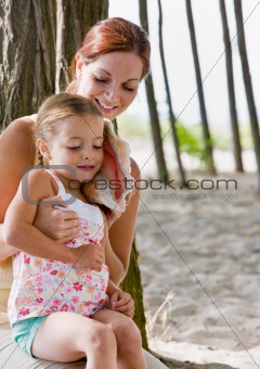 Mother and daughter listening to seashell