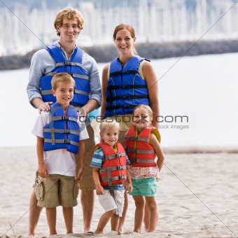 Family wearing life jackets at beach