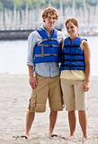 Couple wearing life jackets at beach